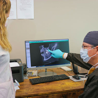 A dentist at Singing River Dentistry reviewing a patient's dental x-ray
