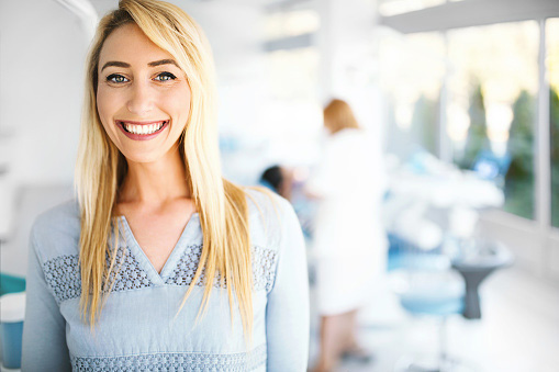 Young female patient smiling after leaving a positive review at Singing River Dentistry in Russellville, AL