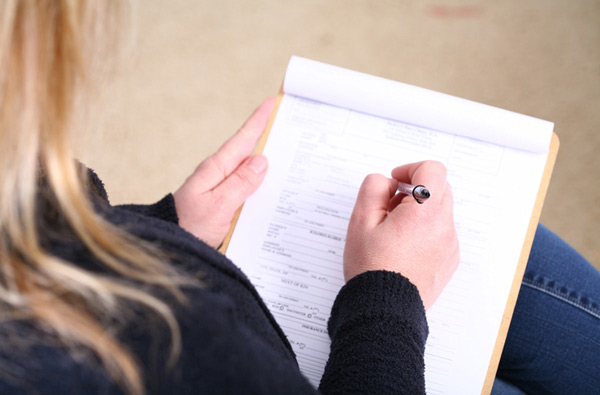 Woman filling out insurance paperwork at Singing River Dentistry